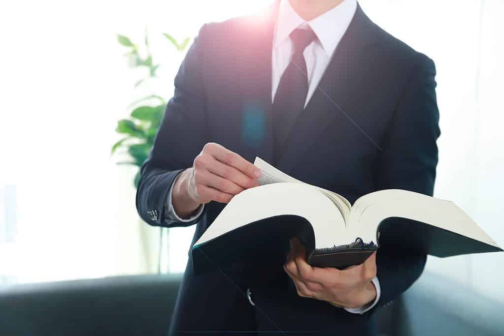 Lawyer reading law book in office